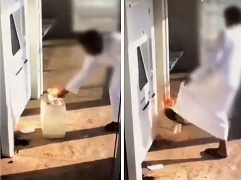 The man is shown setting fire to the bus waiting area in Riyadh.