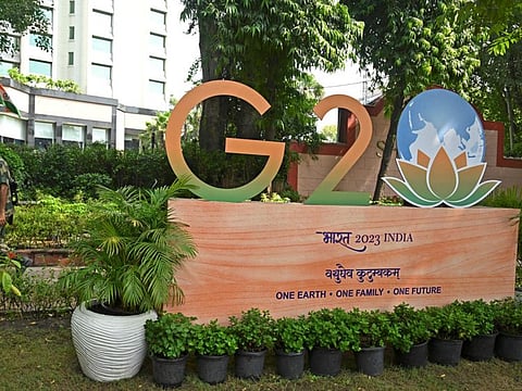 A security personnel walks past the G20 logo installed along a street in New Delhi on September 7, 2023.