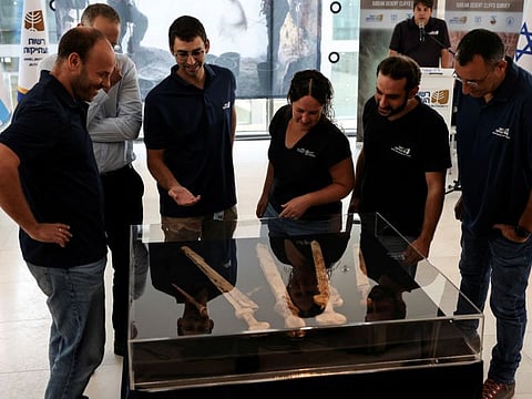 The team who discovered ancient swords, believed by the Israel Antiquities Authority to be from the Roman era dating back 1,900 years and found in a weapons cache in a cave in an Israeli desert, view their discovery in Jerusalem, September 6, 2023.