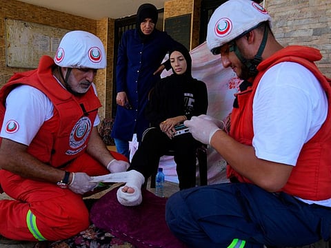 Palestinian Red Crescent workers treat an injured woman at a mosque during clashes between members of the Palestinian Fatah group and militants in the Palestinian refugee camp of Ein Al Hilweh near the southern port city of Sidon, on September 10, 2023.