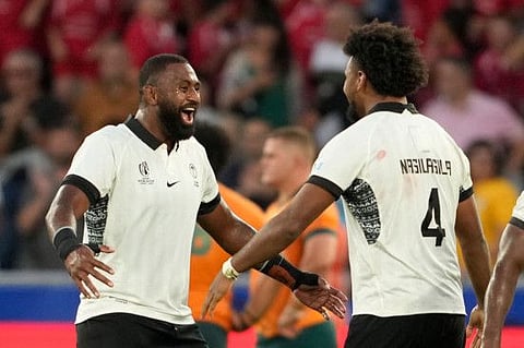 Fiji's Isoa Nasilasila (right) and Temo Mayanavanua celebrate Fiji's victory at the end of the Rugby World Cup Pool C match against Australia at Stade Geoffroy-Guichard in Saint-Etienne on Sunday.