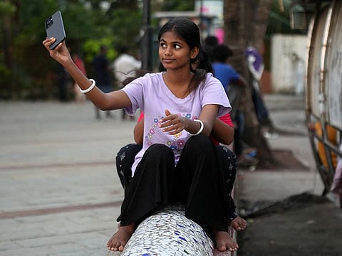 Maleesha Kharwa, 15, a model and Instagram Influencer, takes a selfie next to a bus terminal in Mumbai.