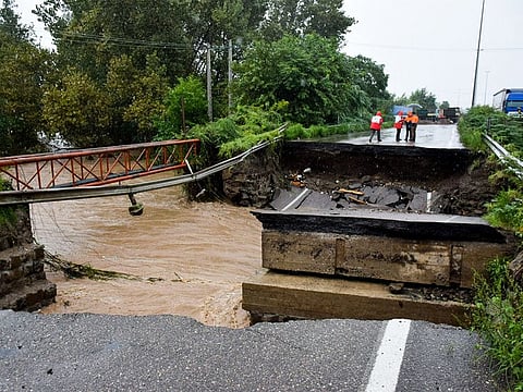 First responders stand along a broken highway amidst heavy flooding in Iran's northwestern city of Astara in Gilan province close to the border with Azerbaijan on September 18, 2023.