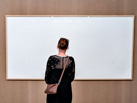 A woman stands in front of an empty frame hung up at the Kunsten Museum in Aalborg, Denmark.