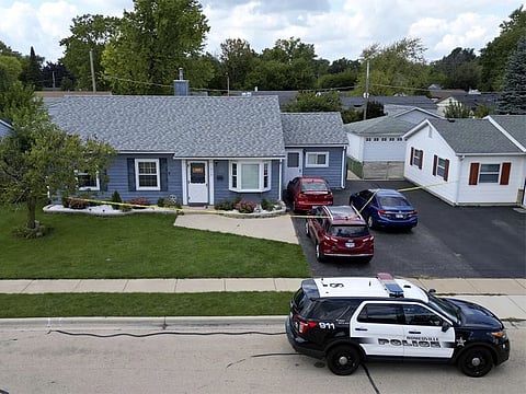 Romeoville police continue to investigate Sunday's quadruple homicide inside of a home on Monday, September 18, 2023, in Romeoville Illinois. The home where the murders took place has two red vehicles in the driveway and is surrounded by yellow crime tape.