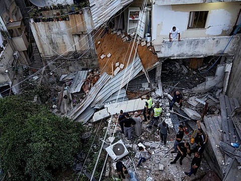 Palestinians inspect a damaged building following an Israeli army raid in Nour Shams refugee camp in the northern West Bank on September 24, 2022.