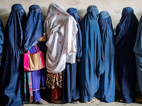 File photo: Afghan women wait to receive food rations distributed by a humanitarian aid group, in Kabul.