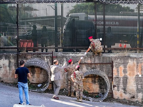 Lebanese Army investigators inspect bullet holes and collect forensic evidence next to the entrance of US Embassy in Aukar, a northern suburb of Beirut, on September 21, 2023.