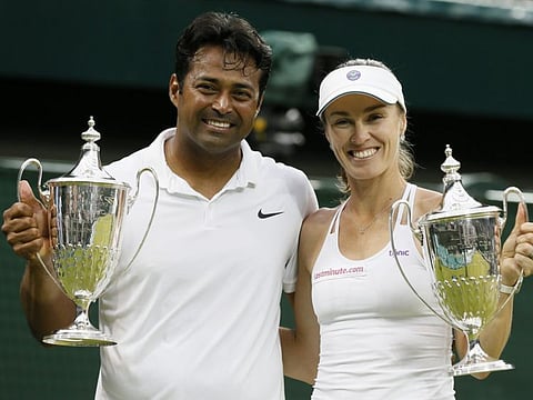 Leander Paes of India and Martina Hingis of Switzerland show off their trophies after winning their Mixed Doubles Final match at the Wimbledon Tennis Championships in London in 2015.