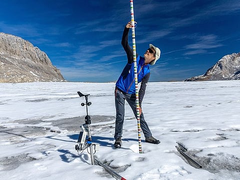 Glaciologist at ETHZ and head of the Glacier Monitoring in Switzerland (GLAMOS) Matthias Huss takes note of the decrease of ice, amid climate change on the Plaine Morte glacier in Crans-Montana, Switzerland.