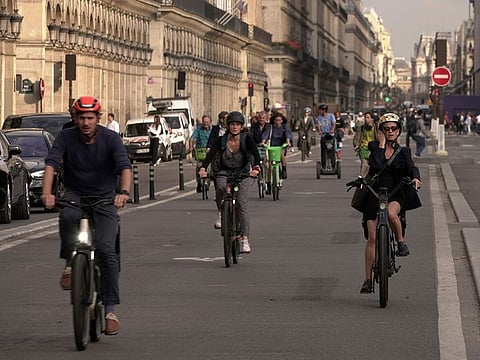 People ride on Rivoli street in Paris, Wednesday, Sept. 13, 2023.