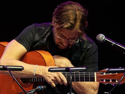 US guitarist Al Di Meola clutches his chest shortly before struggling to walk off the stage at the Arenele Romane concert venue during his performance in Bucharest, Romania, Wednesday evening, Sept. 27, 2023.