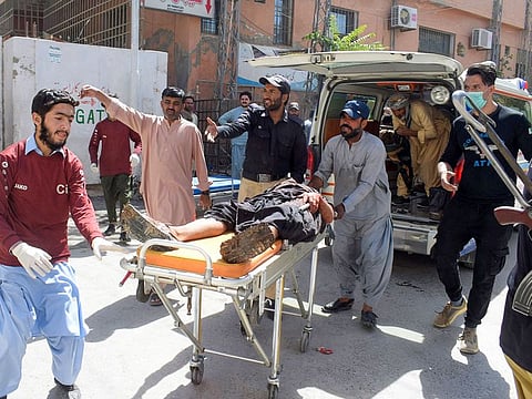 Volunteers carry a blast victim on a stretcher at a hospital in Quetta on September 29, 2023, after a suicide bombing in Mastung district.