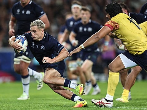 Scotland's wing Darcy Graham (left) runs with the ball to score a try during the Rugby World Cup Pool B match against Romania at Pierre-Mauroy stadium in Villeneuve-d'Ascq near Lille, northern France, on Saturday