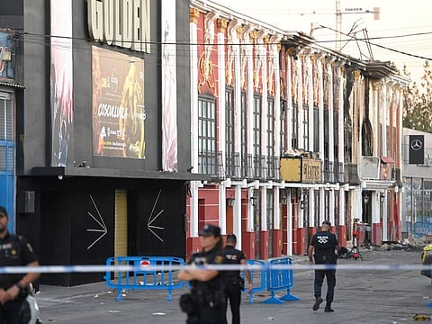 This picture taken on October 2, 2023 shows police officers blocking access after a fire in a nightclub that at least killed 13 people at a nightclub in Murcia.