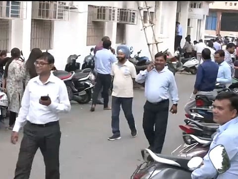 Videos shared by ANI show people rushing out of office buildings following the quake