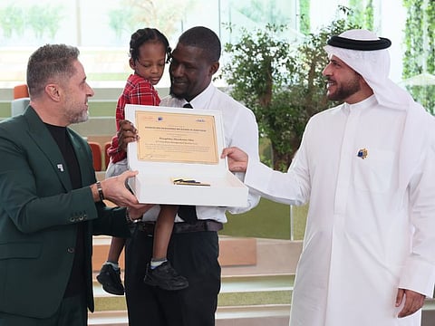 Winner Theophilus Efetobome Obie accepts an award with his daughter from Major-General Obaid Muhair bin Suroor, Deputy Director-General of the General Directorate of Residency and Foreigners Affairs (GDRFA) in Dubai, and Chairman of the Taqdeer Award and Fares Saeed, Chairman and CEO of SEE holding, at the Wajadto Nafsi press conference and Taqdeer Award on October 5, 2023.