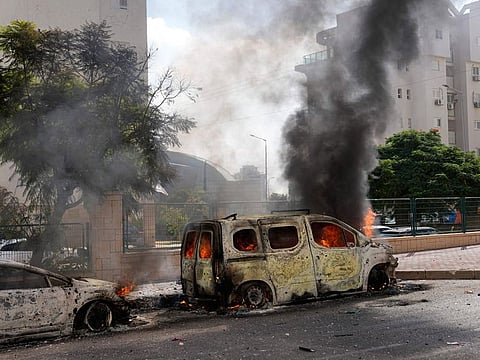 Cars are on fire after they were hit by rockets from the Gaza Strip in Ashkelon, Israel, on Saturday, Oct. 7, 2023