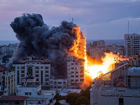 Fire and smoke rise following an Israeli airstrike, in Gaza City, on Saturday, October 7, 2023.