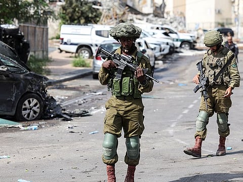 Israeli soldiers patrol near a police station which was the site of a battle following a mass infiltration by Hamas gunmen from the Gaza Strip, in Sderot, southern Israel.