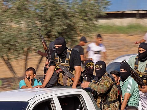 Palestinian militants move towards the border fence with Israel from Khan Younis in the southern Gaza Strip on October 7, 2023.