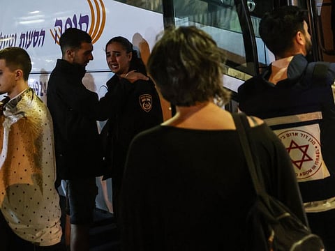 Residents of the southern Israeli city of Netivot bordering the Gaza Strip wait near a bus before being evacuated to central Israel on October 7, 2023.