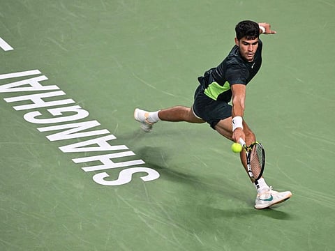 Spain's Carlos Alcaraz hits a return against Britain's Daniel Evans in their men's singles match during the Shanghai Masters on Monday.