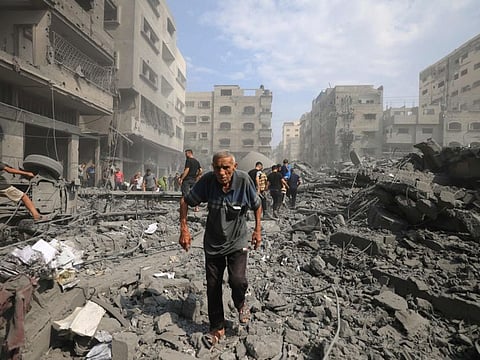 Palestinians evacuate the area following an Israeli airstrike on the Sousi mosque in Gaza City on October 9, 2023.