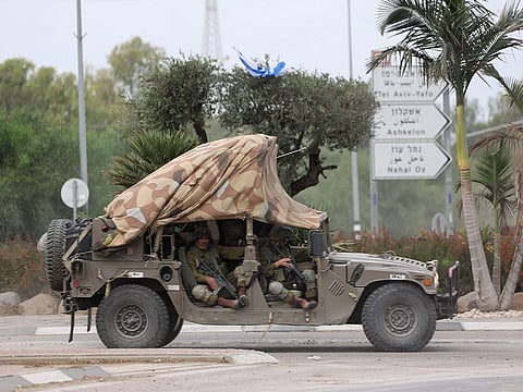 Israeli soldiers patrol a road near the border fence with Gaza.