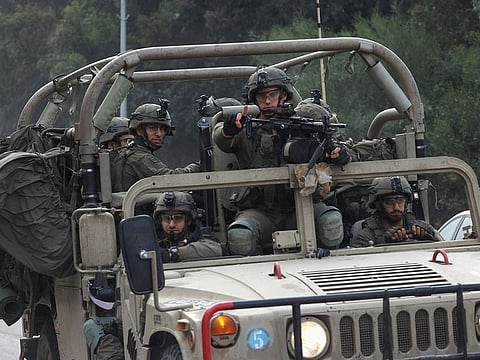 Israeli soldiers patrol a road near the border fence with Gaza.