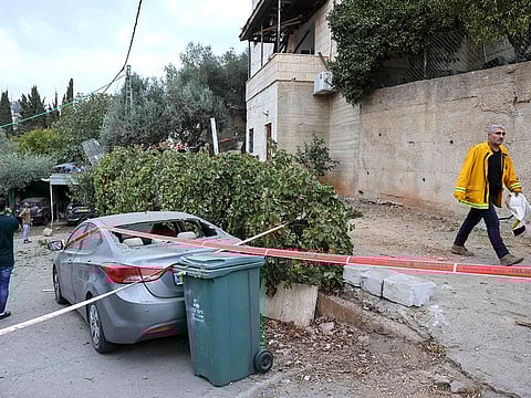 A mana walks past a car hit by rockets fired from Gaza in the Arab-Israeli town of Abu Ghosh near Jerusalem.