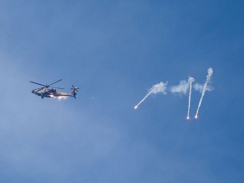An Israeli Apache helicopter releases flares while patrolling over the Israel-Gaza border on October 11, 2023. Israel declared war on Hamas on October 8 following a shock land, air, and sea assault by the Gaza-based militant group.