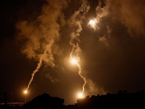 Flares burn in the sky as seen from Ramyah near Israel, October 11, 2023.