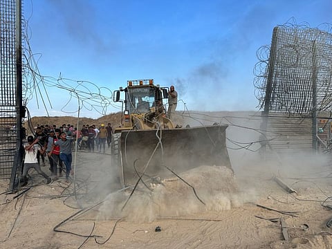 Palestinians break into the Israeli side of Israel-Gaza border fence after gunmen infiltrated areas of southern Israel, October 7, 2023.