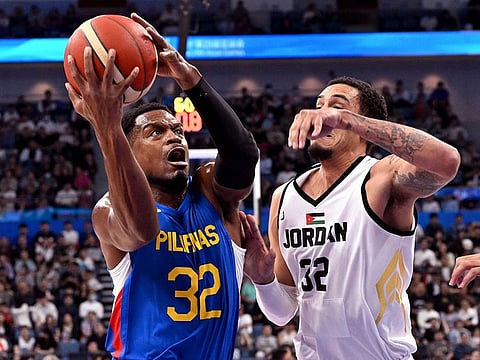 Philippines' player Justin Brownlee (L) is challenged by Jordan's John Bohannon during the men's gold medal basketball game between Jordan and Philippines at the 2022 Asian Games in Hangzhou in China's eastern Zhejiang province on October 6, 2023.