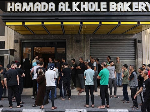 Palestinians queue to buy bread outside a bakery in Gaza city on the sixth day of ferocious fighting between Hamas and Israel.