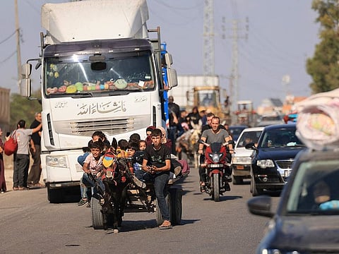 Riding a donkey drawn cart as family along with hundreds of other Palestinian carrying their belongings flee following the Israeli army's warning to leave their homes and move south before an expected ground offensive, in Gaza City on October 13, 2023.