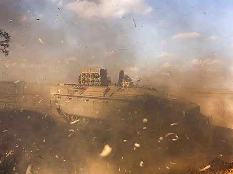An Israeli Armoured Personnel Carrier (APC) is obscured as it whips up dust near Israel's border with the Gaza Strip, in southern Israel October 15, 2023.
