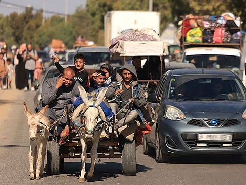 Palestinians carried belongings through the rubble-strewn streets of Gaza City.