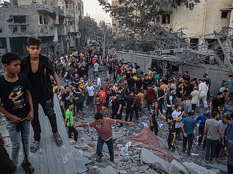 People gather in a neighbourhood in Rafah in the southern Gaza Strip, after it was hit by an Israeli strike.