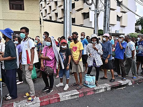 Senior citizens queuing up for daily food donations from Bangkok Community Help Foundation, nearby the Grand Palace in Bangkok.