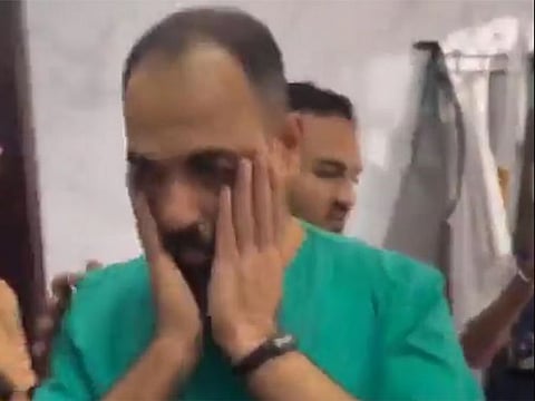 The doctor reacts after looking at his son’s body at the hospital on Sunday.