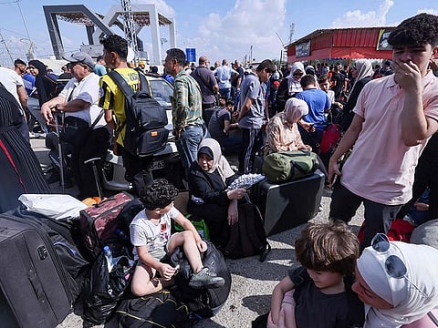 Palestinians, some with foreign passports hoping to cross into Egypt and others waiting for aid wait at the Rafah crossing in the southern Gaza strip.