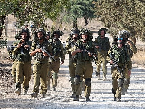 Israeli troops patrol at an undisclosed location along the border with the Gaza Strip on October 19, 2023.