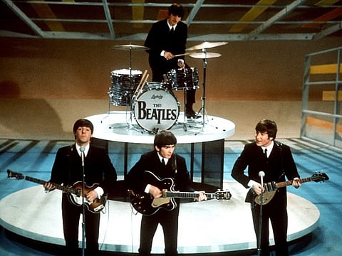 The Beatles, foreground from left, Paul McCartney, George Harrison, John Lennon and Ringo Starr on drums perform on the CBS "Ed Sullivan Show" in New York on  Feb. 9, 1964.