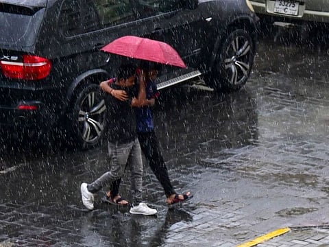 Residents braving the rain in Sharjah on Thursday.