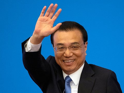 Then Chinese Premier Li Keqiang waves during a press conference after the closing session of the National People's Congress in Beijing's Great Hall of the People on March 15, 2019.