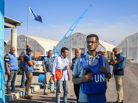 Relief workers await the arrival of the trucks carrying humanitarian aid at the United Nations Relief and Works Agency for Palestinian Refugees (UNWRA) warehouse facility in Deir Al Balah, Gaza. Israel has allowed only a small trickle of aid to enter from Egypt, some of which was stored in one of the warehouses that was broken into, UNRWA said.