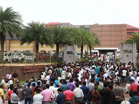 People stand outside a convention centre where multiple blasts occurred during a religious gathering in Kochi, India, October 29, 2023.