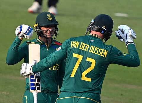 South Africa's Quinton de Kock (left) celebrates with teammate Rassie van der Dussen after scoring a century during the Cricket World Cup match against New Zealand in Pune on Wednesday.